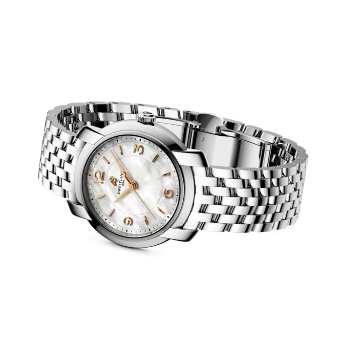 A wrist watch with a silver stainless steel link bracelet, a round silver case, and a white mother-of-pearl dial with gold-tone hands and numerals. The brand name 'breitling' is visible on the dial.