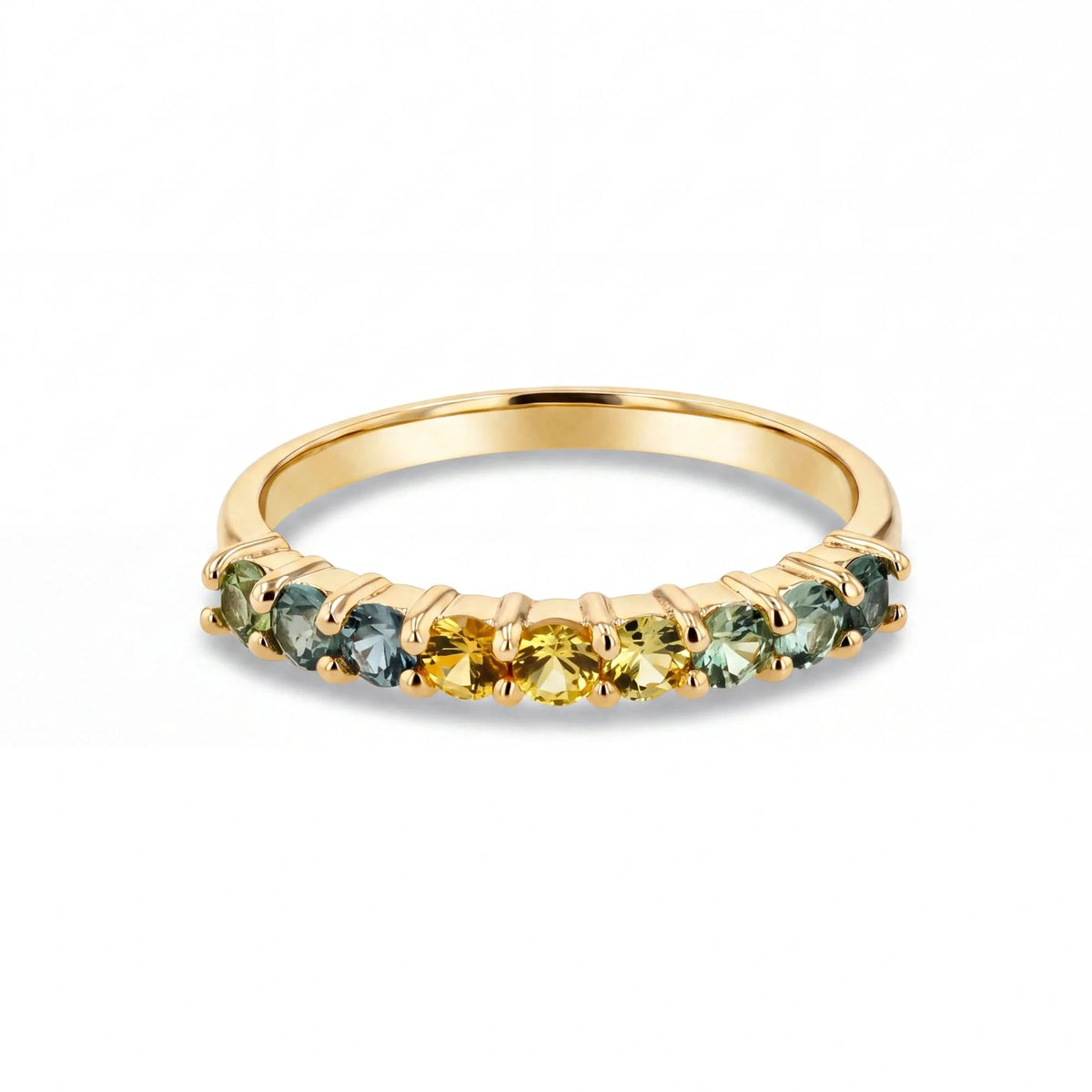 A gold ring featuring a row of small, round-cut gemstones in shades of yellow, light green, and blue, set against a clean white background.