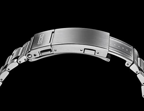 Close-up of a metallic watch band with 'Seiko' branding on a black background