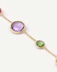 Close up of Gold bracelet with multicolored gemstones on a white background