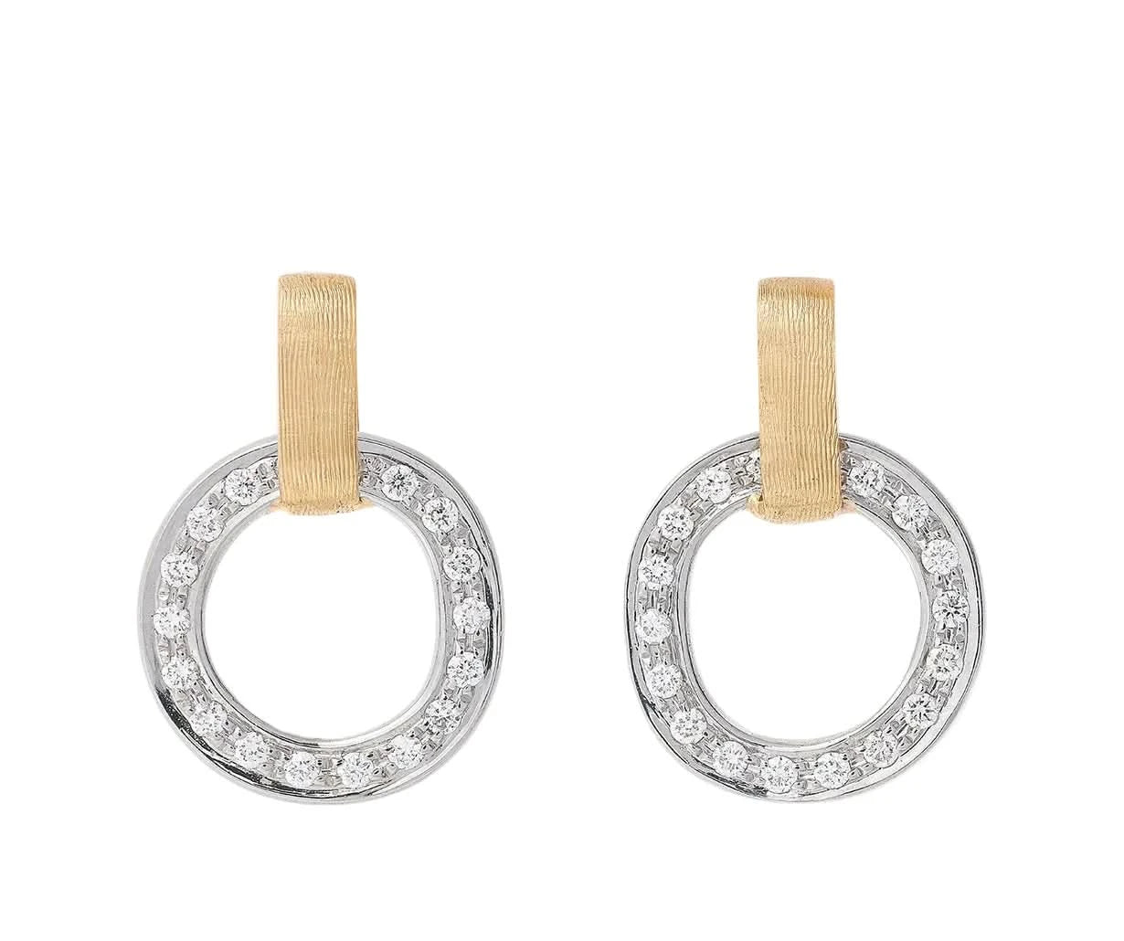 A pair of silver-toned hoop earrings with a circle of clear pavé-set stones and a vertical gold-tone ribbon loop at the top, shown on a light cream background.