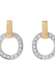 A pair of silver-toned hoop earrings with a circle of clear pavé-set stones and a vertical gold-tone ribbon loop at the top, shown on a light cream background.