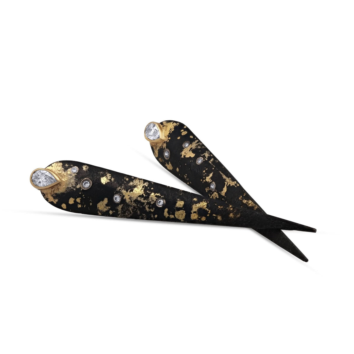 Angled view of Logan James Talon PS long tapered black steel earrings with 18K and 22K yellow gold details and diamonds