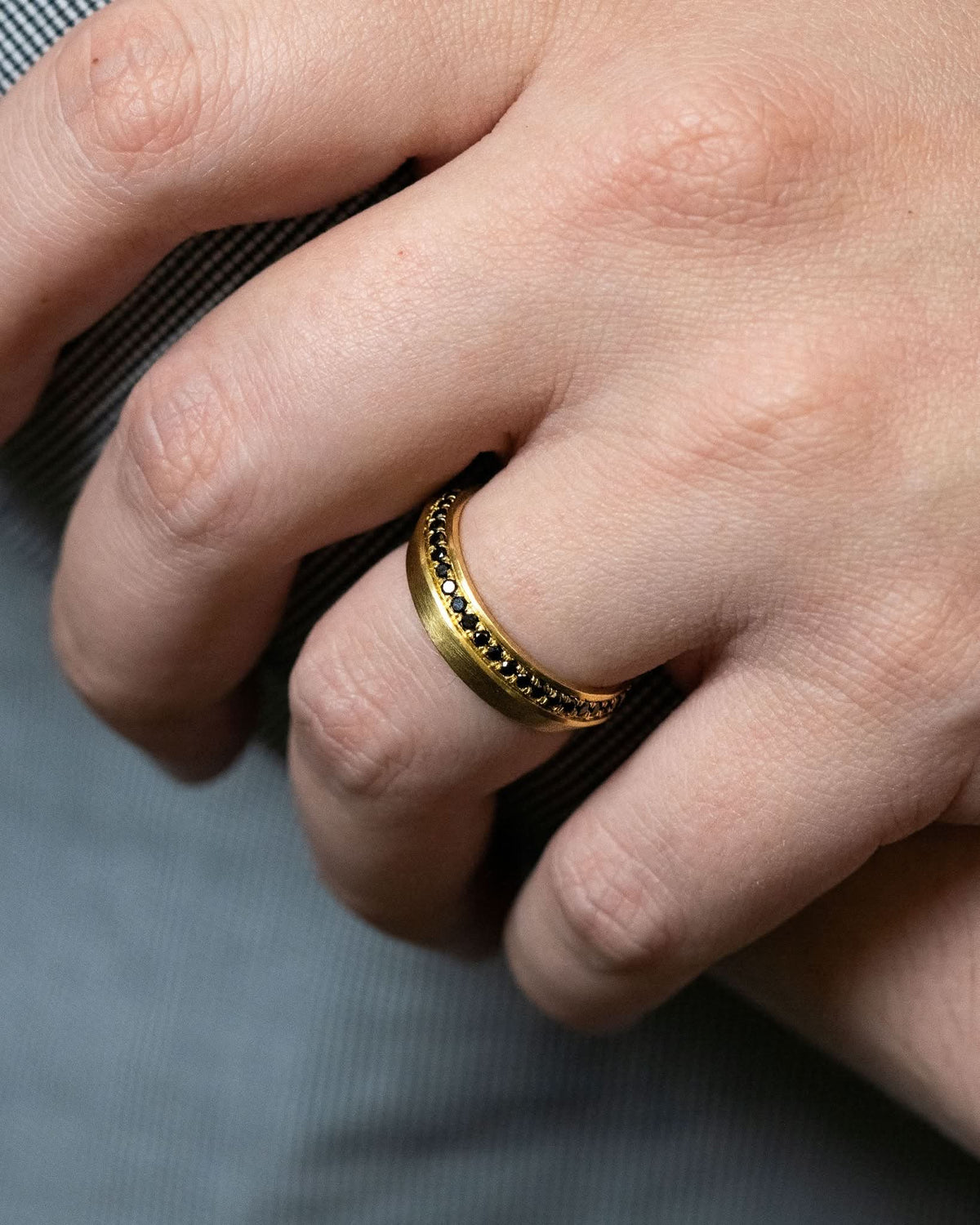 Logan James Urban black diamond 18K yellow gold ring worn on hand close-up