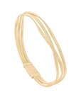 Gold triple strand bracelet on a light beige background