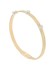 A slim yellow gold bangle bracelet with a textured band and three small diamond-set accents, shown on a light white background.