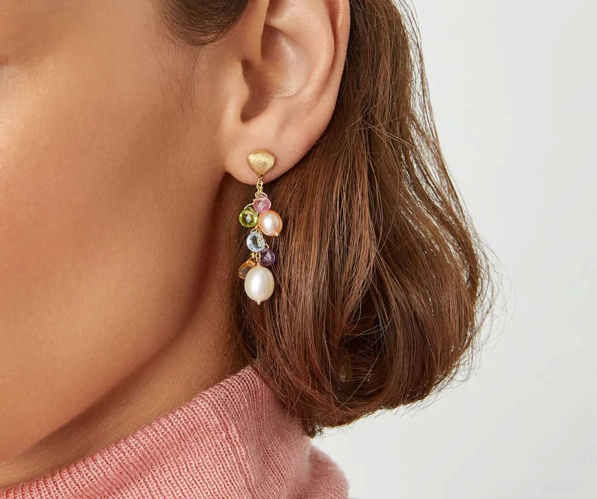 Close-up of an ear wearing a colorful beaded earring with a blurred background