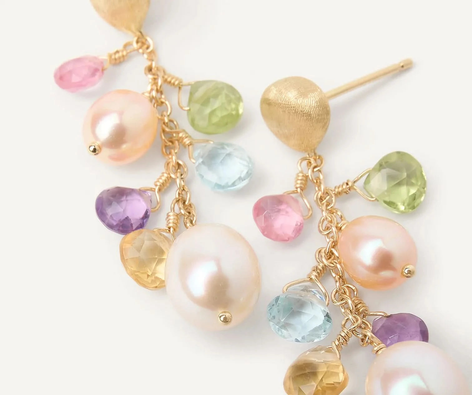 Multicolored gemstone and pearl earrings on a white background
