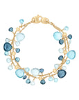 Gold bracelet with blue gemstones on a white background