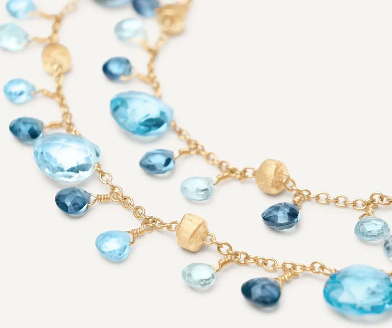 Gold and blue beaded double strand bracelet on a white background close up