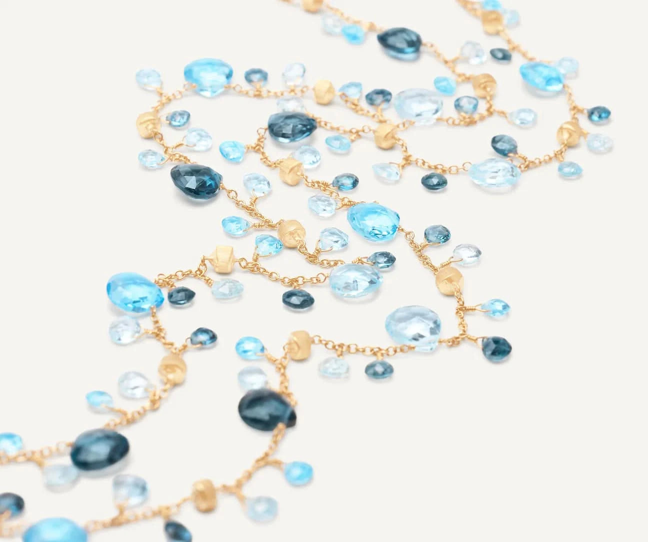 Necklace with blue and gold beads on a white background laid out
