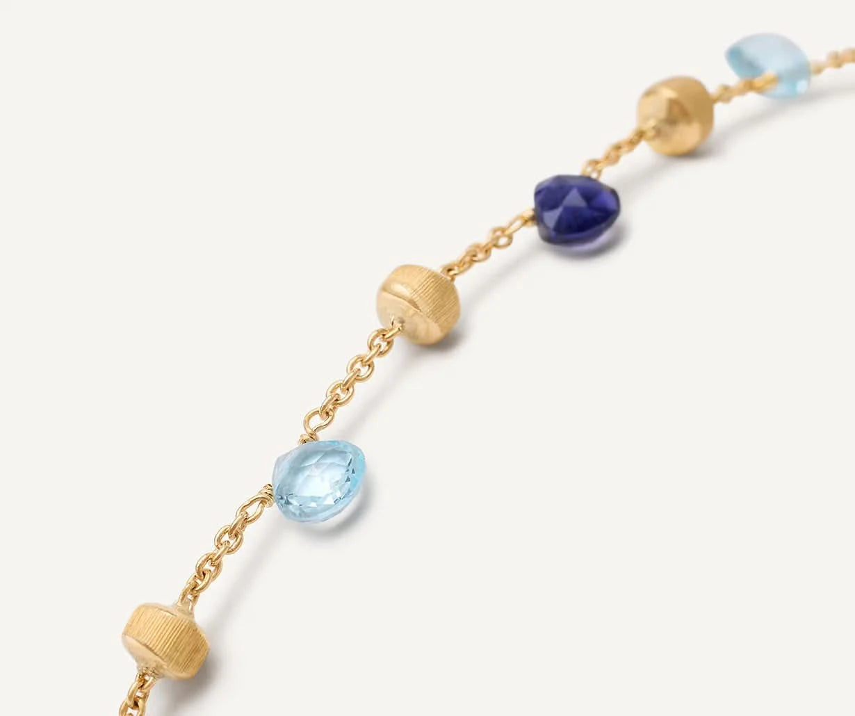 Gold bracelet with blue gemstones on a white background close up