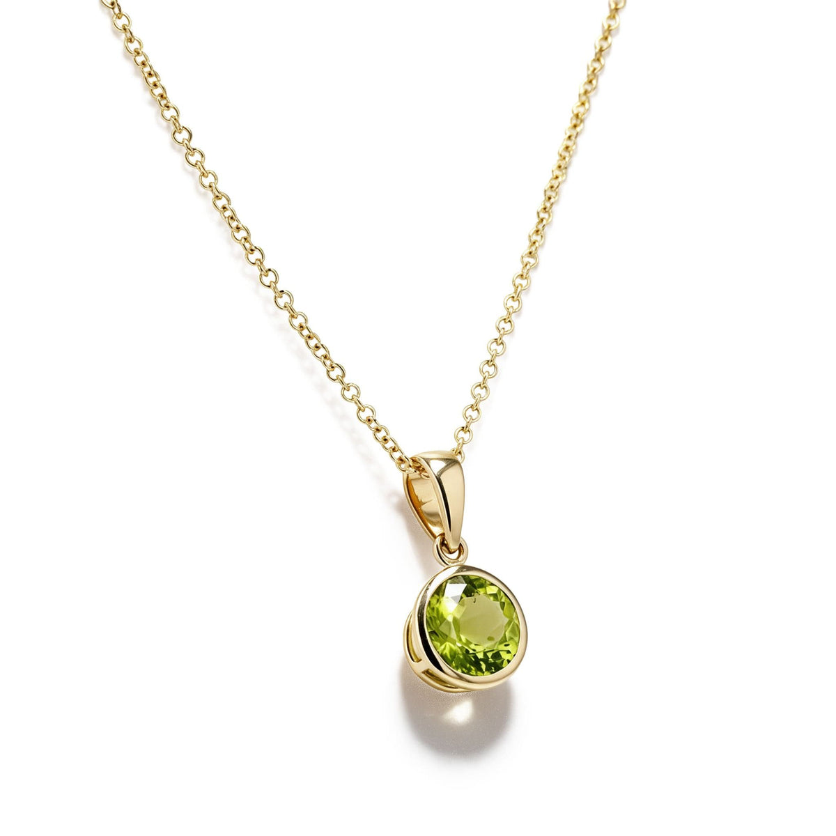Side view of 14K yellow gold 1.46ct round peridot bezel pendant with polished bail; chain not included