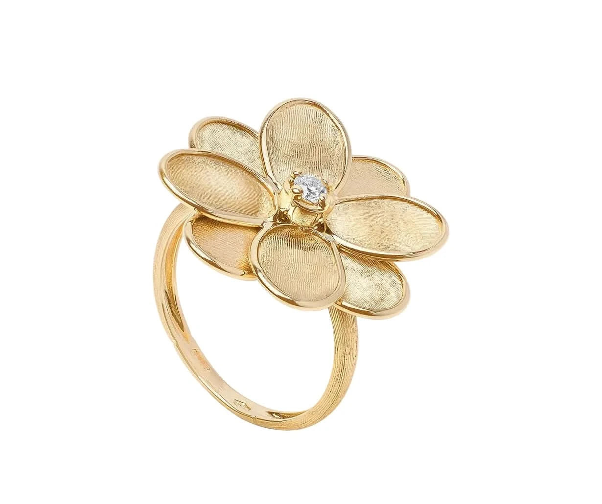 A gold flower ring with five textured petals and a small clear gemstone at the center, shown on a white background.