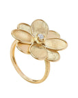 A gold flower ring with five textured petals and a small clear gemstone at the center, shown on a white background.