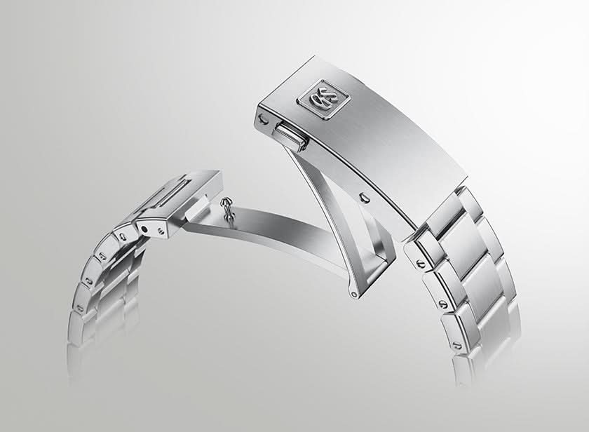 A close-up studio shot of a polished stainless steel watch band clasp and adjacent links on a light gray gradient background.
