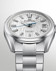 A Grand Seiko stainless steel watch with a textured silver dial, silver-tone case, and matching link bracelet, shown against a light gray gradient background.