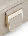 Close-up of a beige case with a gold buckle on a white background
