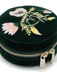 Round black velvet case with floral embroidery on a white background top view