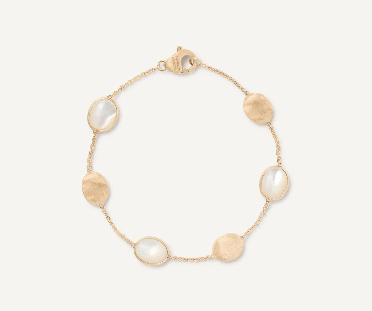 Gold bracelet with mother of pearl stones on a white background