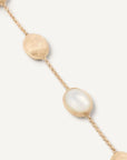 Gold bracelet with mother of pearl beads on a white background close up
