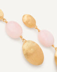 A pair of gold and pink drop earrings with textured oval gold tops and smooth light pink oval beads, shown on a clean off-white background.