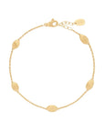 Gold bracelet with ovalshaped charms on a light beige background