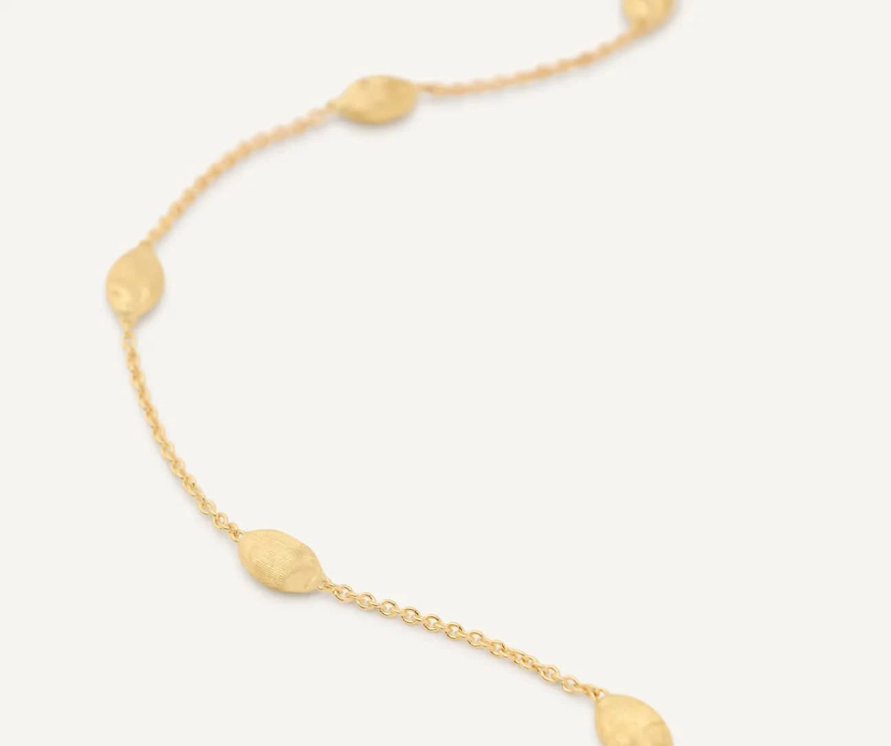 Gold necklace with round pendants on a blurred  background