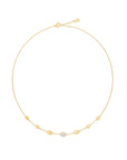 A delicate yellow gold chain necklace with small gold bead accents and a central pavé diamond accent, displayed on a light off-white background.