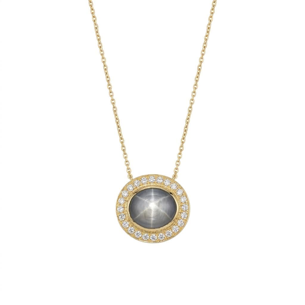 A custom-made 14K yellow gold pendant necklace by Skeie's Jewelers, featuring an oval 4.61 carat gray-blue star sapphire cabochon displaying a prominent six-rayed star, surrounded by a 0.33 carat round diamond halo on an 18-inch chain.