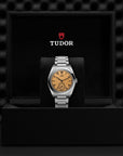 Tudor watch in a black display case with the Tudor logo.