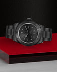 Black watch on a red platform with a dark background