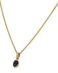 yellow pendant and chain with blue center stone and diamond accents angled on a white background