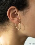 1.5 x 25mm Yellow Gold Tube Hoop Earrings by Carla | Nancy B. Modeled